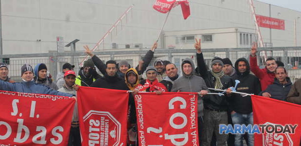 da Parmatoday „ Dopo l’ennesima notte passata all’interno della tenda montata qui davanti, in via Martiri delle Carzole a Fidenza dal 24 dicembre, i lavoratori del magazzino della Bormioli di Fidenza sono usciti ed hanno iniziato un’altra giornata di sciopero. Non una delle tante che vi abbiamo descritto nei precedenti articoli perchè oggi, 7 gennaio, al termine delle Festività Natalizie, riprende la produzione ma loro non hanno intenzione di andarsene. “Non da qui non ce ne andiamo, la nuova cooperativa ci ha chiesto di rientrare al lavoro sostenendo che l’accordo sarebbe stato firmato dopo, mentre noi facchini – ci […]