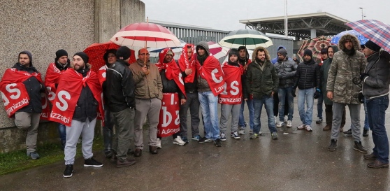 da gazzettadimodena.gelocal.it SPILAMBERTO. «Ci chiediamo quale sia un canale possibile di trattativa dato che, al tavolo prefettizio, la famiglia Levoni è stata disponibile al dialogo ma ha fatto muro con la tipica arroganza di un padrone ottocentesco». Il sindacato SìCobas ha sintetizzato così la drammatica situazione dei 55 operai della coop Alba Service, finiti in mezzo a una strada dopo avere ottenuto il contratto da alimentaristi. Ieri i SiCobas hanno gestito lo sciopero spontaneo davanti allo stabilimento di via Sardegna. In un clima di ricatti, disperazione e illegalità diffusa da rabbrividire, non potevano mancare le camionette della polizia, con […]
