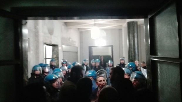 da liberopensiero.eu NAPOLI. Durante il corteo per il NO al referendum, i manifestanti hanno provato ad occupare la sede provinciale del Partito Democratico in Piazza Carità. Questi, però, sono stati fermati dai carabinieri in assetto antisommossa che hanno ritenuto opportuno chiudere i manifestanti all’intero del palazzo stesso, nell’androne delle scale. Le conseguenze di questo gesto sono state ritenute gravi dagli attivisti che, attraverso Facebook, hanno pubblicato foto e post: “Piu di trenta agenti hanno spintonato, minacciato piu di sessanta persone, tra cui donne e bambini, mettendo in stato di fermo un attivista che si trovava pacificamente all’esterno, rilasciato subito […]